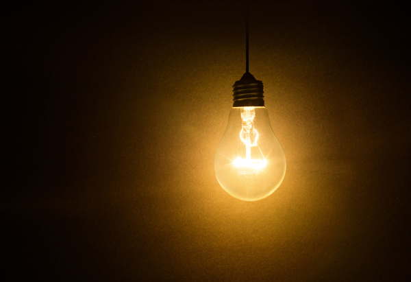 En glödlampa som lyser i ett mörkt rum