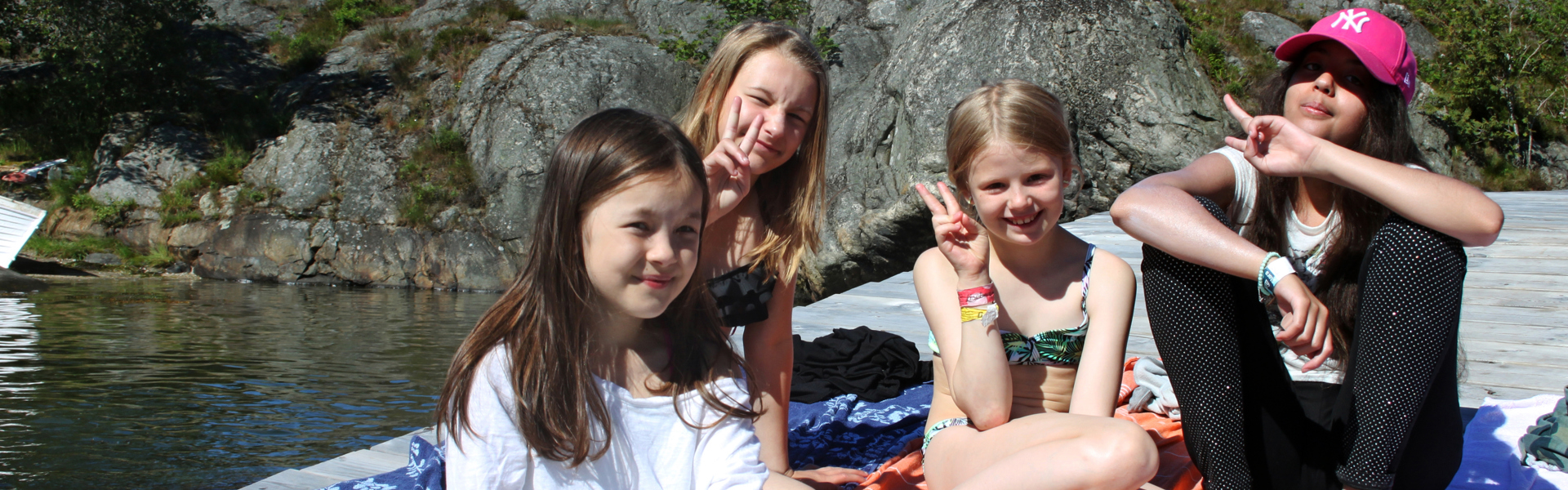 Bilden visar barn på en brygga i skärgården.