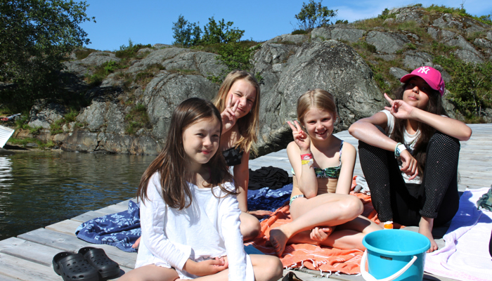 Bilden visar barn på en brygga i skärgården.