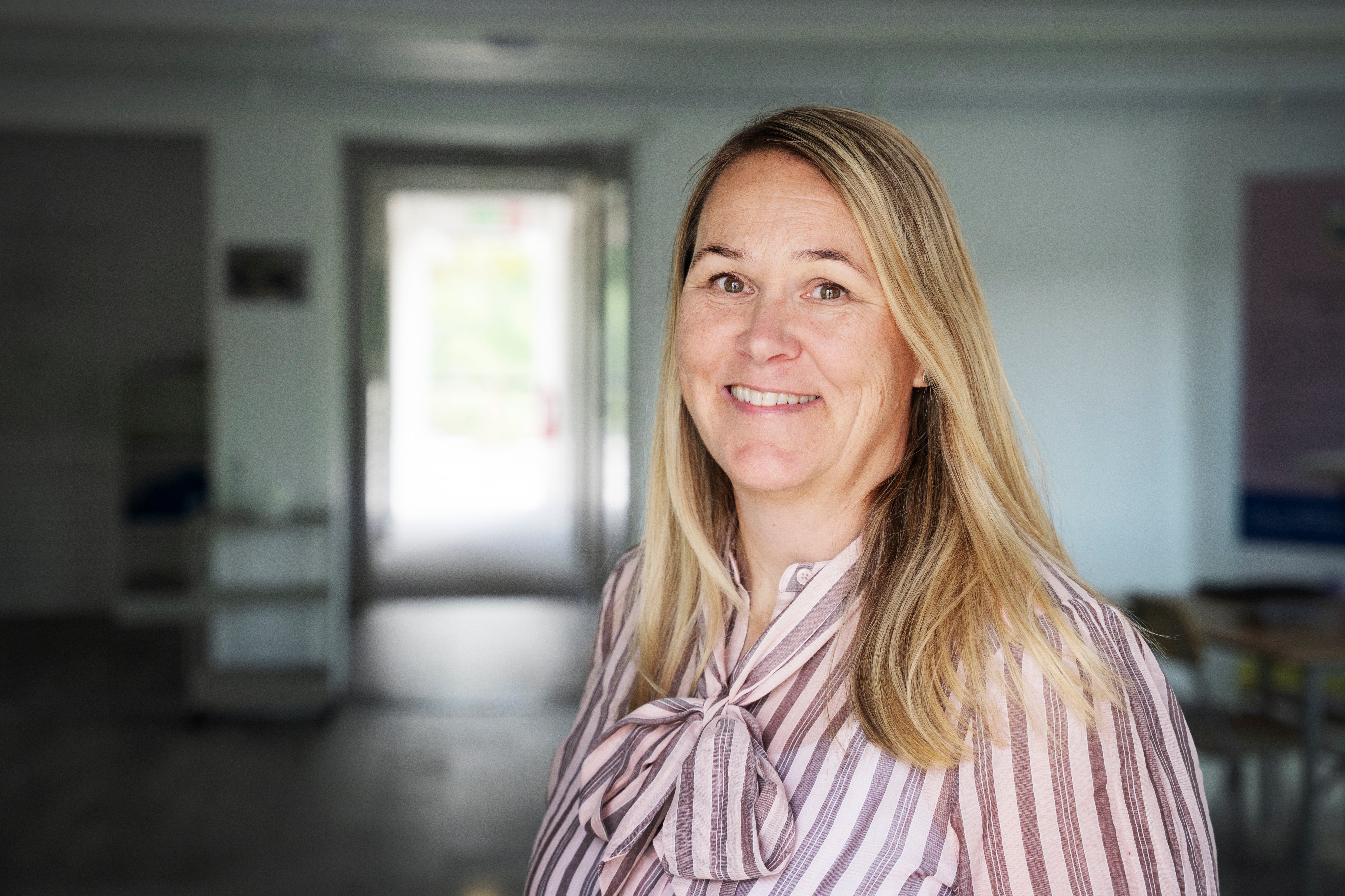 Carin Daal, chef kommunikation och social h&aring;llbarhet Malm&ouml;, portr&auml;ttbild. Blond l&aring;ngt h&aring;r, rosa knutblus, och hon ler in i kameran