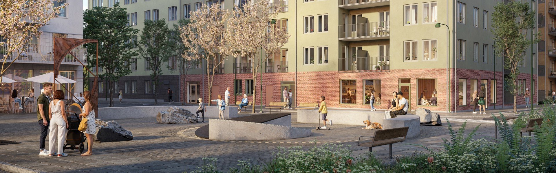 En solig innergård framför ett flerbostadshus med grön fasad och röd tegelsockel, där människor i olika åldrar sitter på bänkar, pratar, leker och promenerar bland träd, planteringar och låga betongmurar.