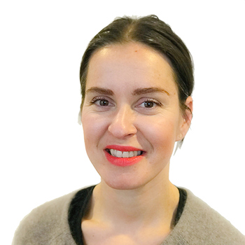 Anna Haraldsson Jensen, porträttbild. Kvinna med brunt hår, ler mot kameran