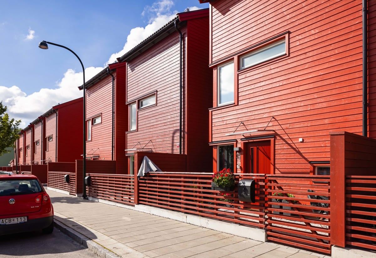 Framsidan av fasaden som består av röd träpanel. 