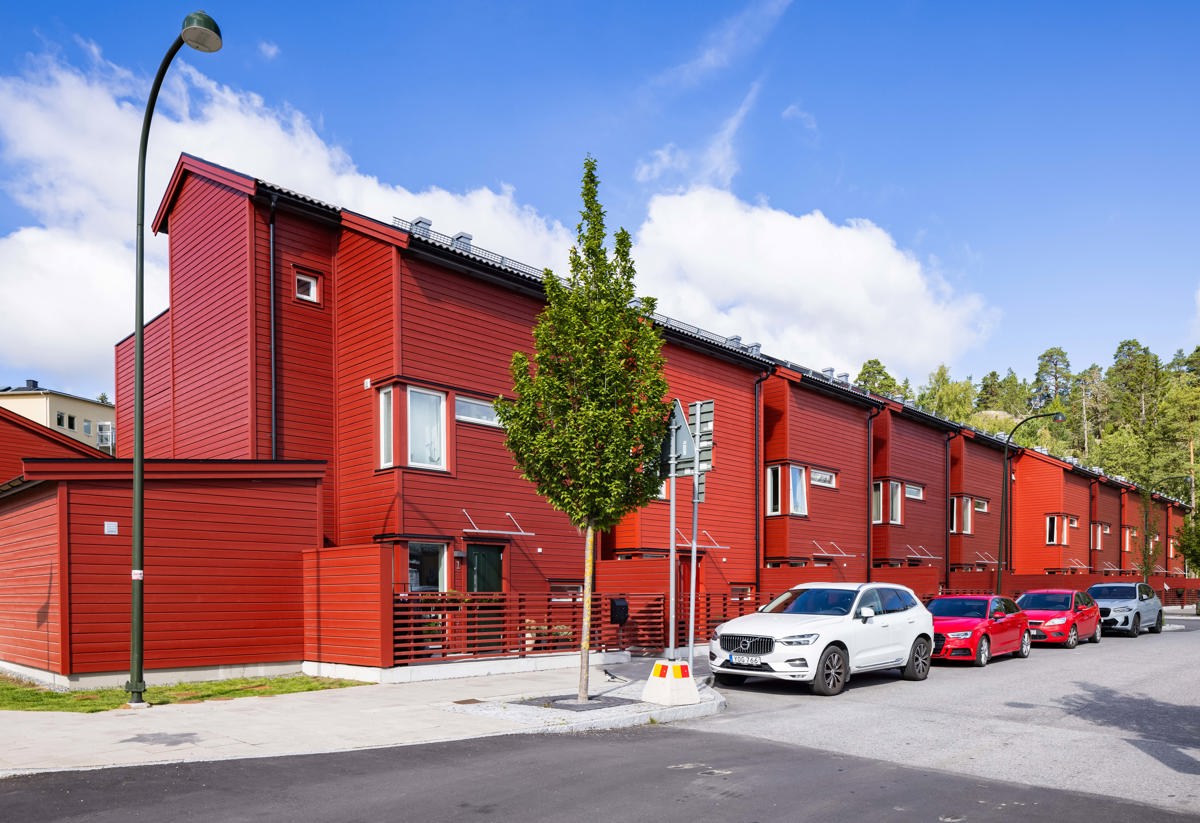 Fasaden av Vårtriangeln som består av röd träpanel där foto är taget från gatan.