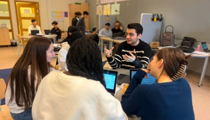 Elever sitter i ett klassrum och samtalar