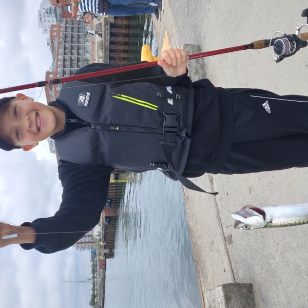 Pojke som visar upp en fisk han har fångat