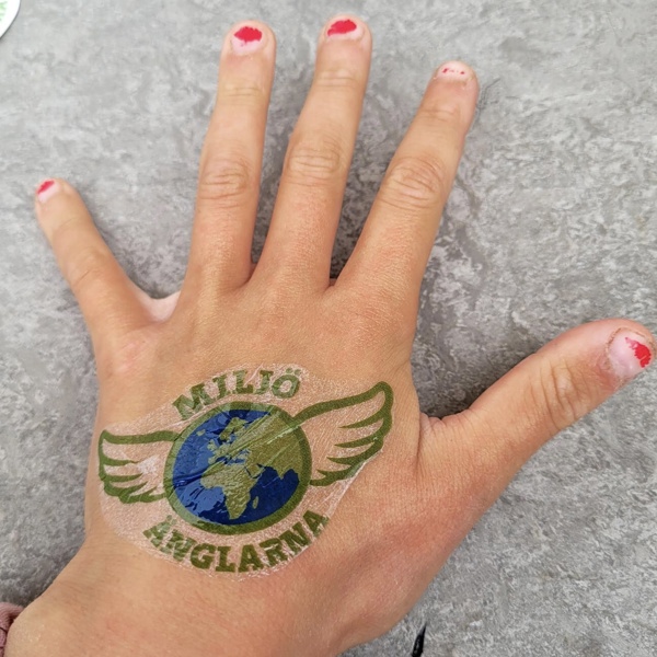 Ett barns hand med miljöänglar logan