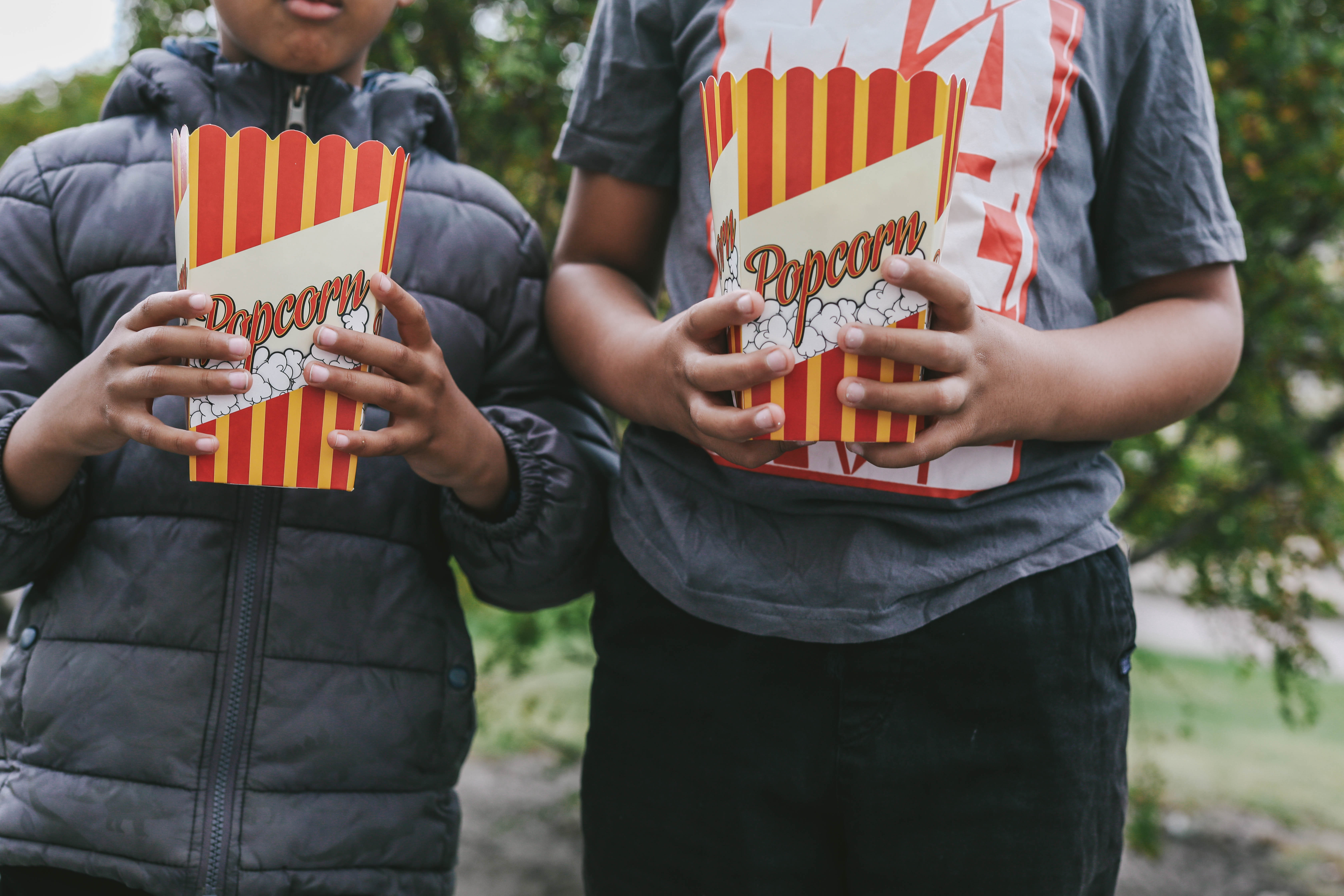 Två mindre barn som håller i varsin popcorn bägare fylld med popcorn på en av stena fastigheters gårdsfester som är en del av relationsförvaltningen och arbetet med trygga och trivsamma kvarter