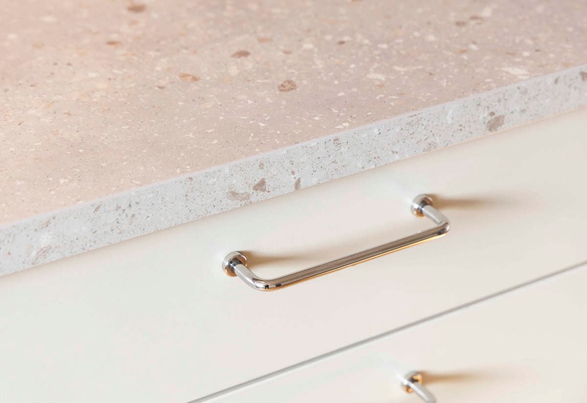 Detaljbild från en plusrenoverad lägenhet med fokus på bänkskiva och handtag