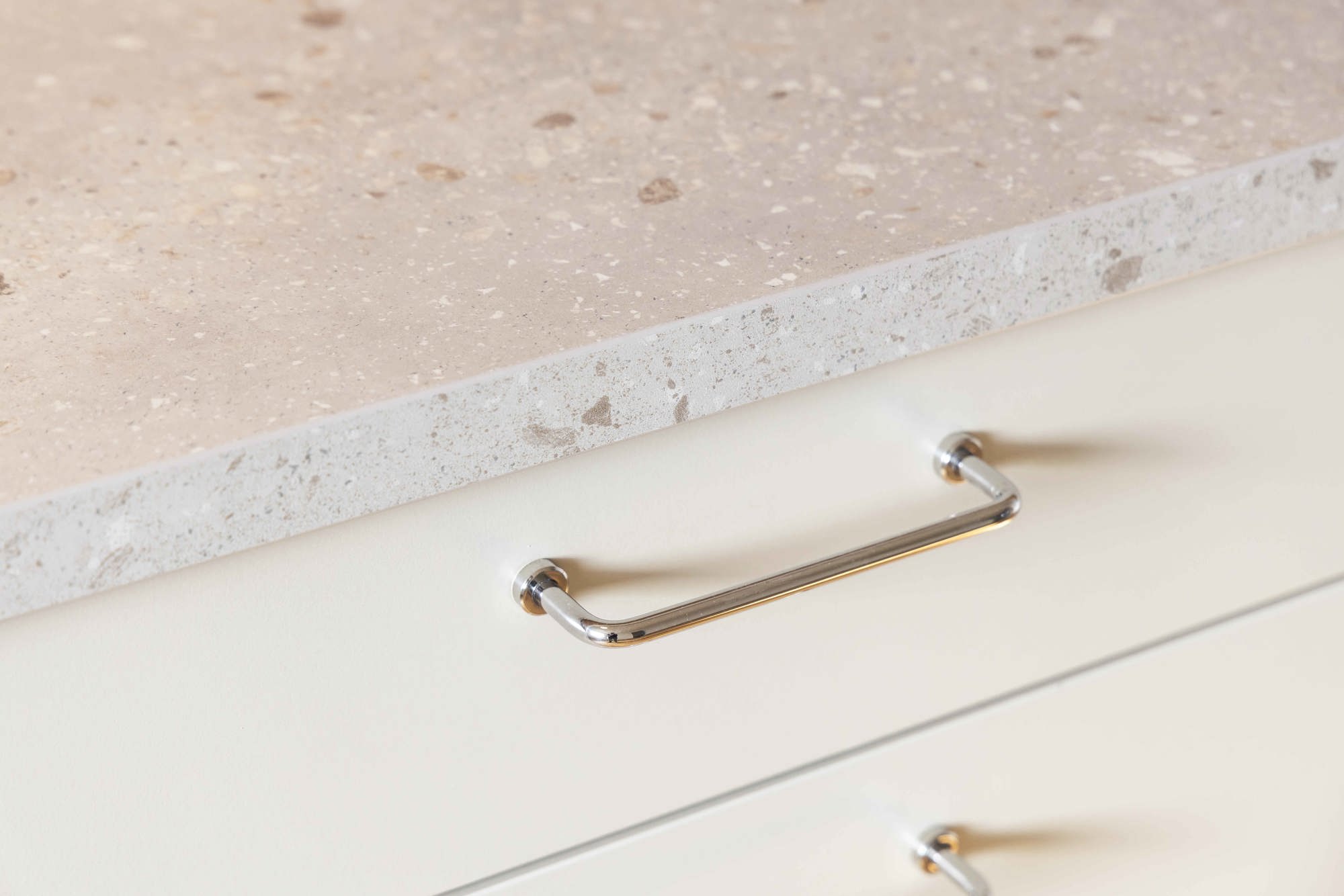 Detaljbild från en plusrenoverad lägenhet med fokus på bänkskiva och handtag