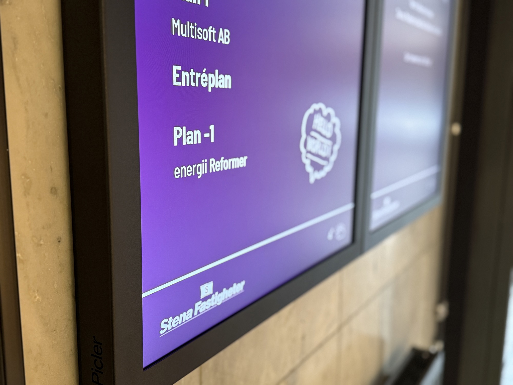 En digital porttavla som visar vilka hyresgäster som sitter i fastigheten. Fokuset är på energii reformer som ligger på plan -1.