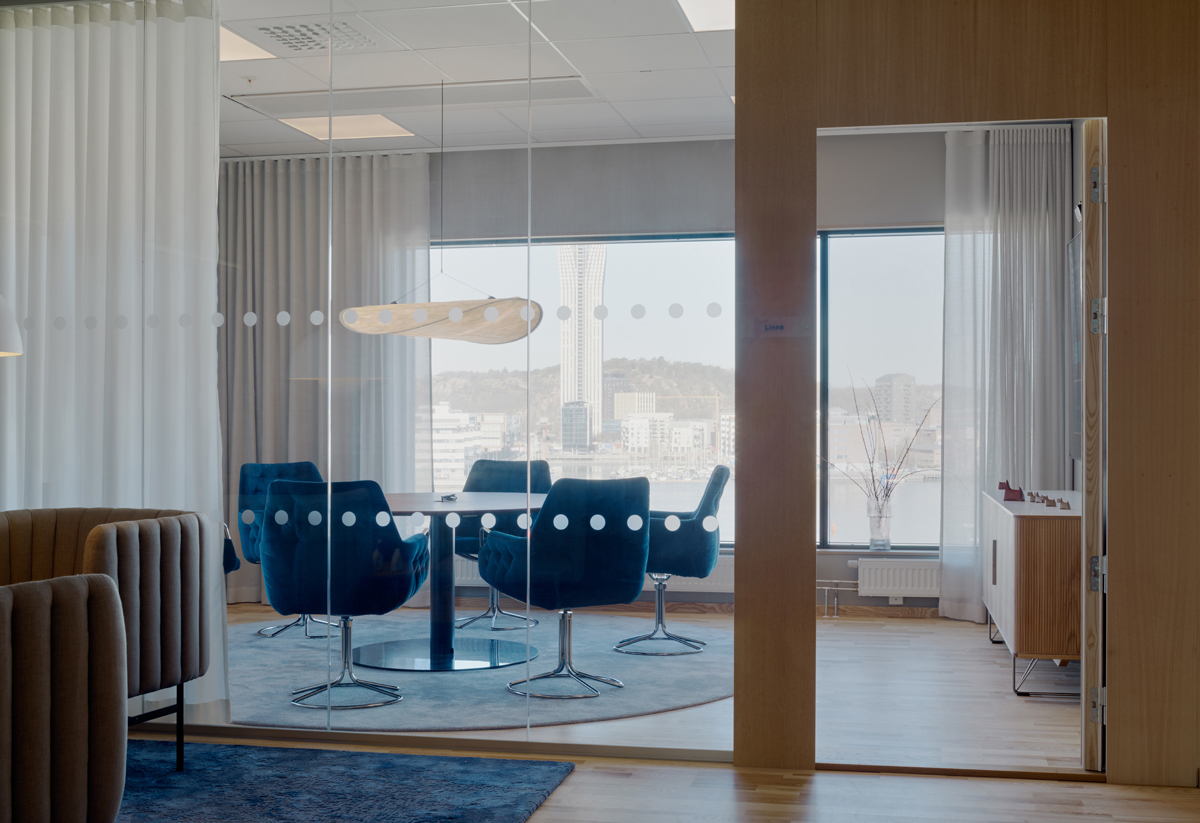 Mötersum med glasväggar och stort fönster, inredning i blått och vitt