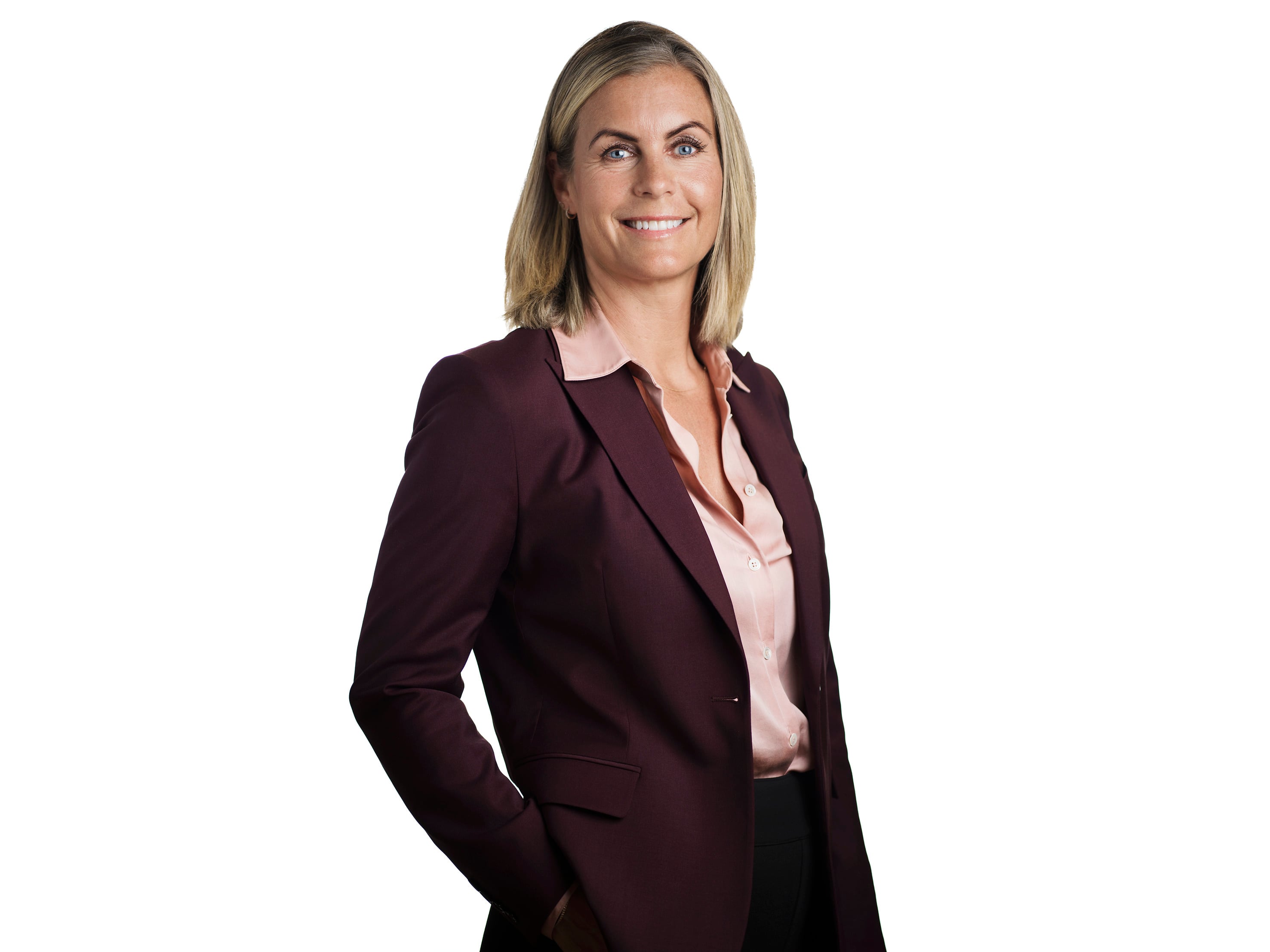 Sofia Granlund, En kvinna i halvkroppsporträtt står mot vit bakgrund. Hon har axellångt blont hår och bär en vinröd kavaj över en ljusrosa blus. Hon ler mot kameran med ena handen i fickan.
