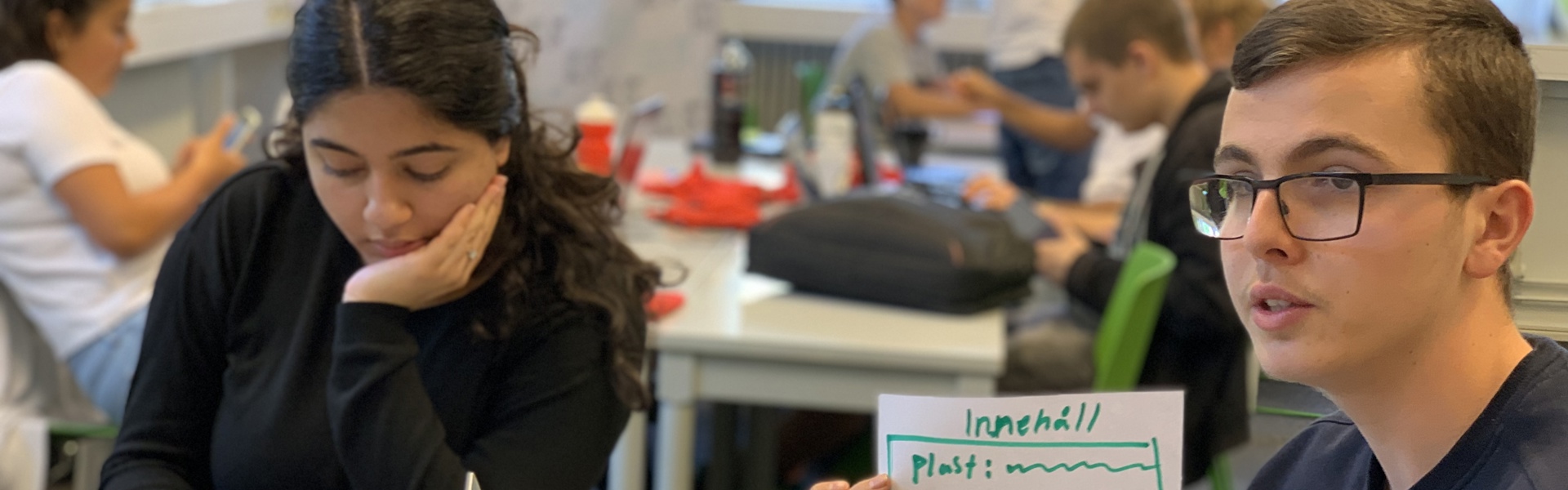 Bild på ungdomar som jobbat som förändringsagenter. En kille visar upp sitt arbete och en tjej sitter i bakgrunden vid sin dator.