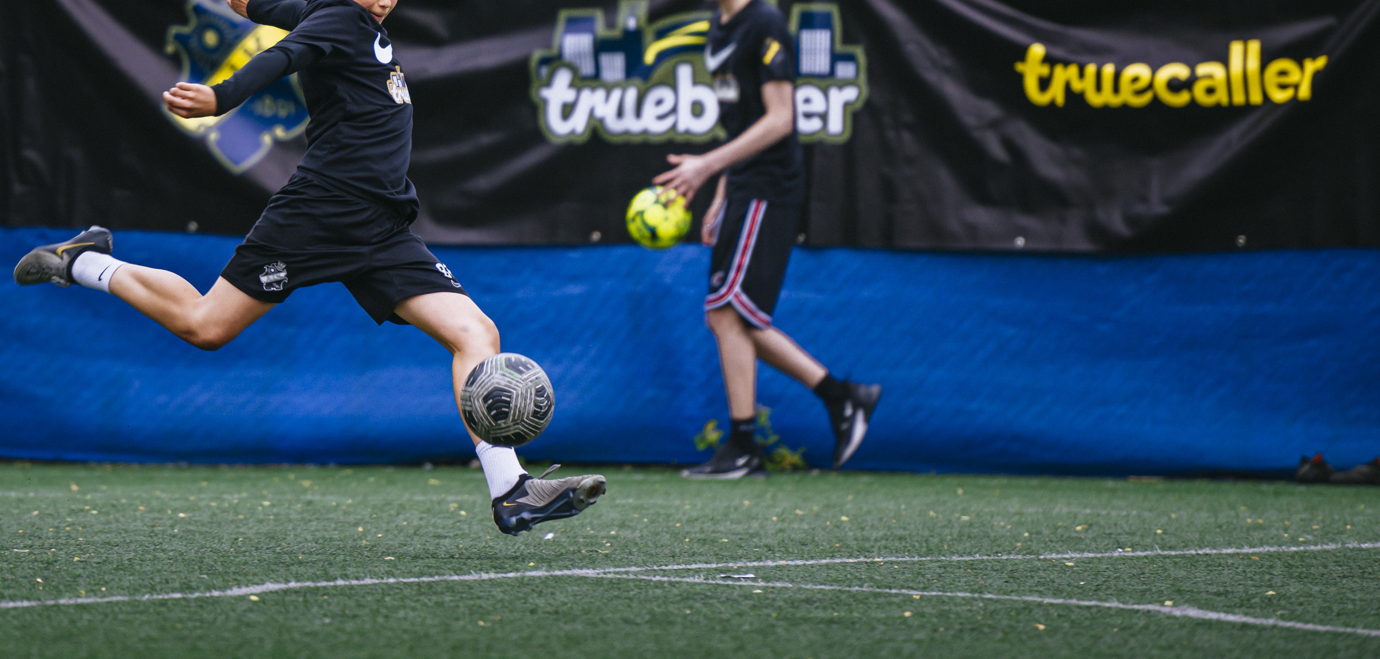 En person sparkar en fotboll