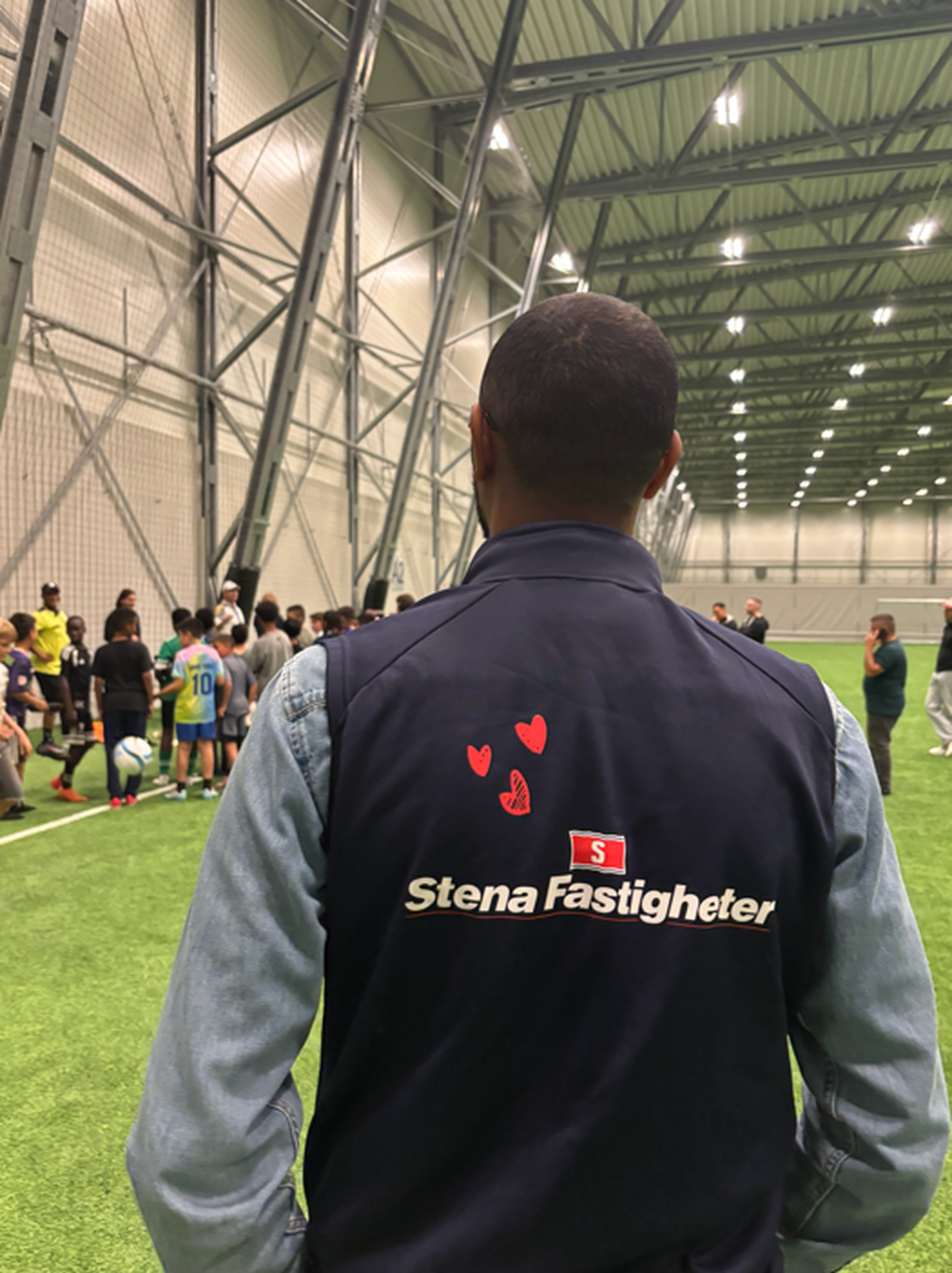 Kollega på AIK kvällsfotboll med väst och logga på ryggen
