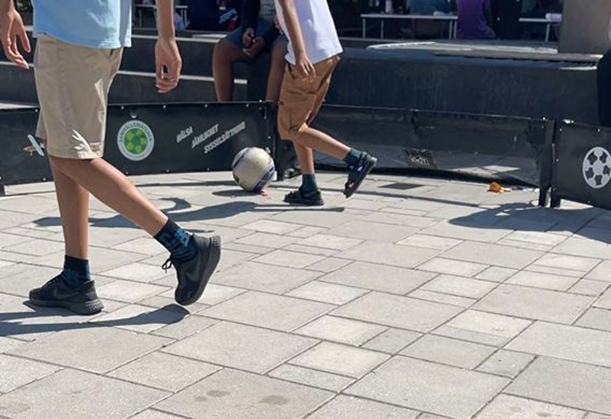 Två barn som spelar streetfotboll. 