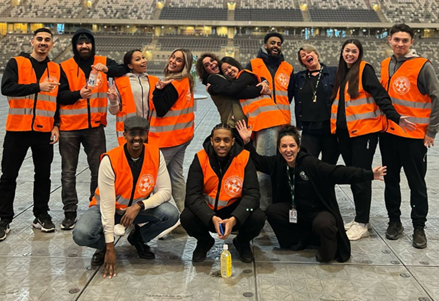 Gruppbild på alla sportvärdar som har orangea västar.