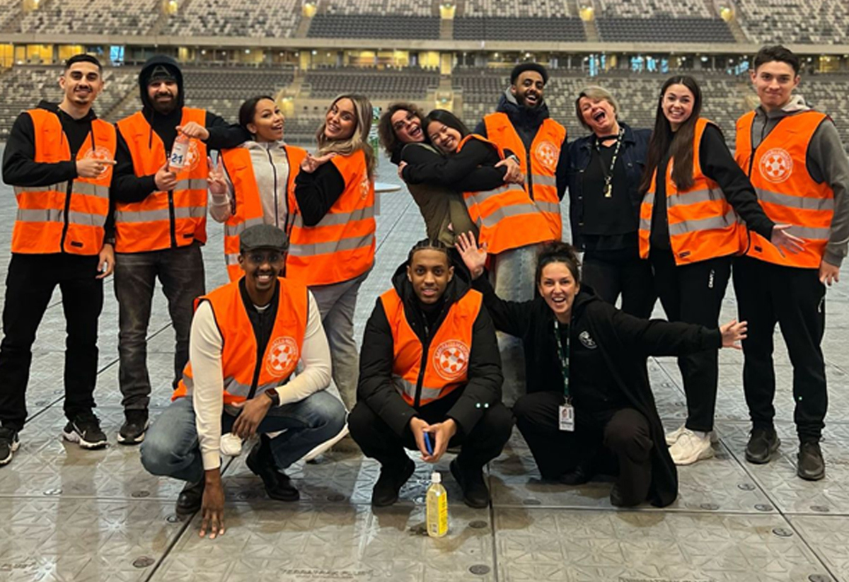 Gruppbild på alla sportvärdar som har orangea västar.