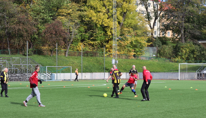 Ett gäng äldre män som spelar gåfotboll på en fotbollsplan. 