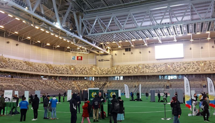 Mässa inne på en fotbollsarena med folk som minglar runt
