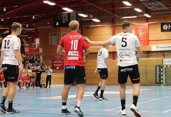 Bild från handbollsplan med spelare från ett rött och vitt lag.