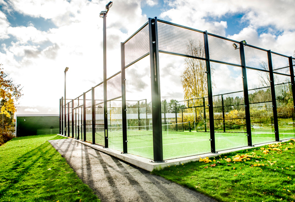 Padelbana utomhus med gräs runt om.