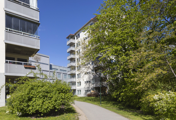 Flerfamiljshus i en grönskande miljö.