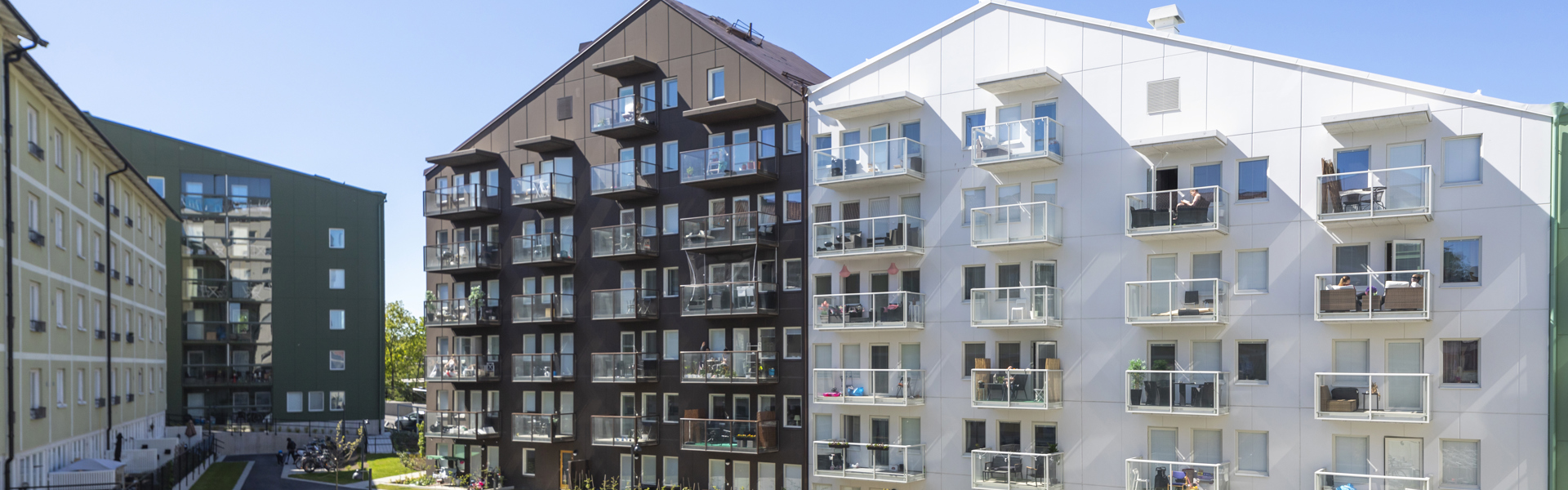 Ett vitt flerfamiljshus och ett brunt flerfamiljshus.