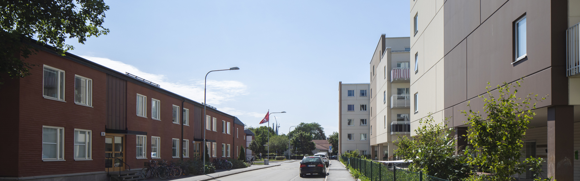 En gata med röda hus på vänster sida och vita på höger sida.
