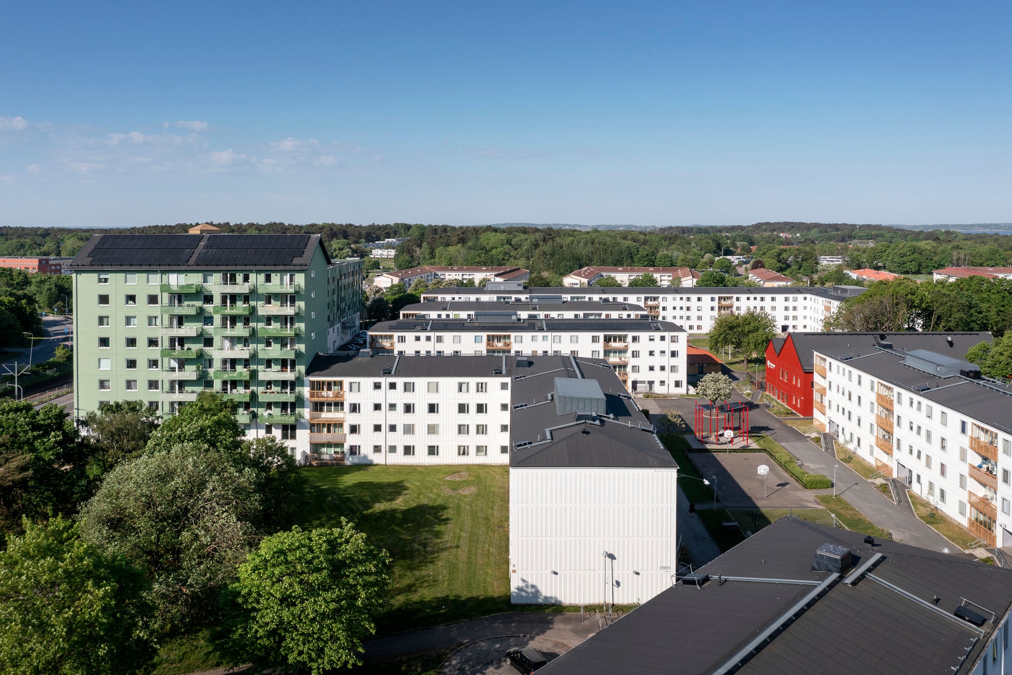 Bild över en stor gård med vita och gröna hus i Tynnered