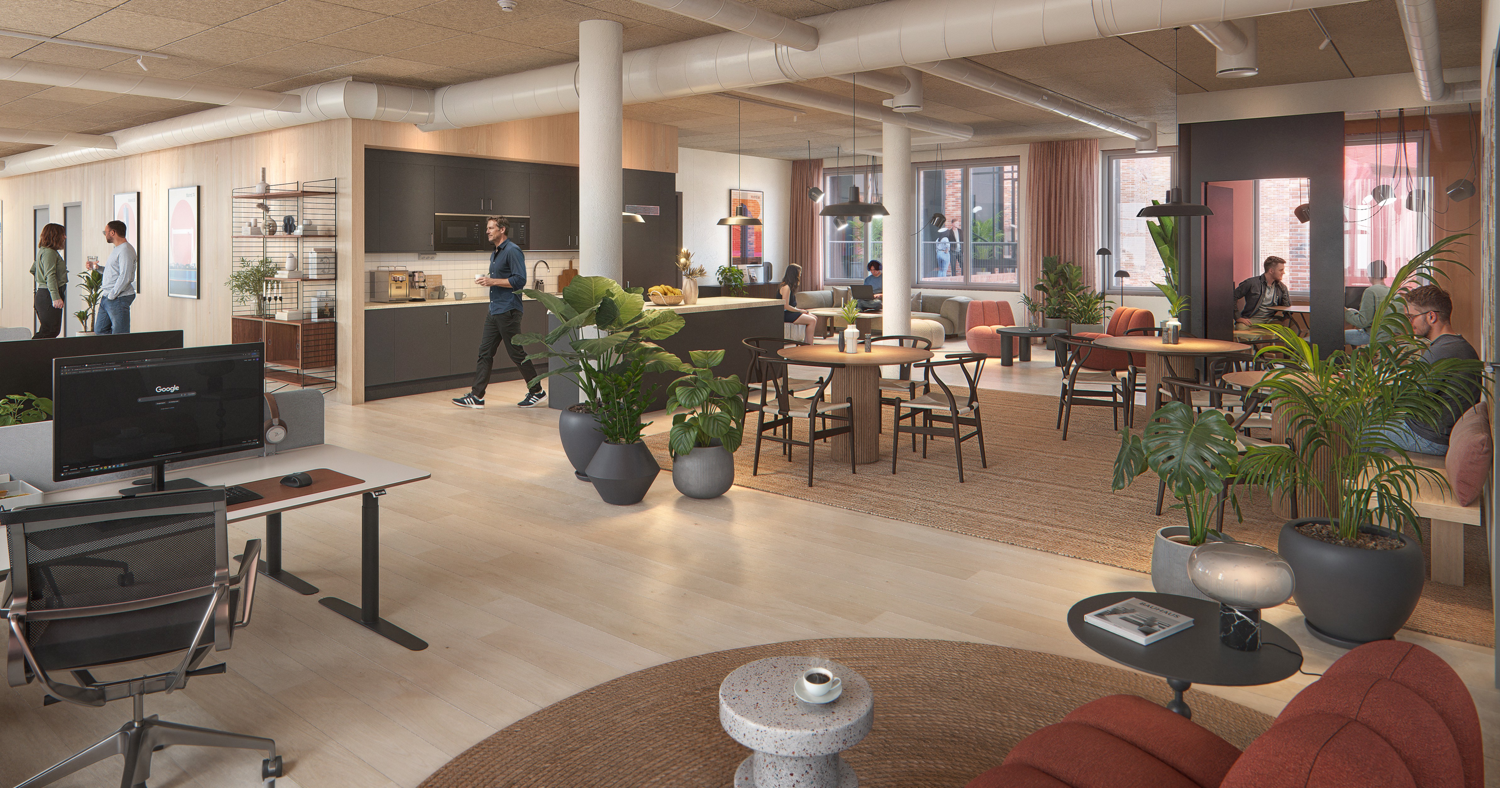 En modern, ljus kontorslounge med öppet kontorslandskap. Flera personer sitter och arbetar vid bord och soffor, medan en person går förbi ett kök med mörka skåp i bakgrunden. Stora fönster släpper in dagsljus och rummet är inrett med träbord, mjuka stolar, mattor och många gröna växter som skapar en ombonad känsla.