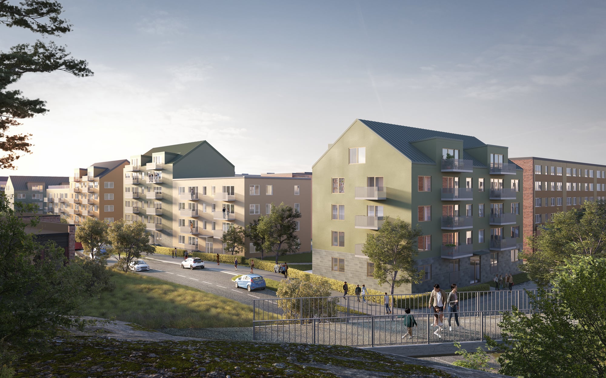 Visuell vy över kvarter med flerfamiljshus. Bro över väg i förgrund och hus medgröna och beigea fasader i bakgrund. 