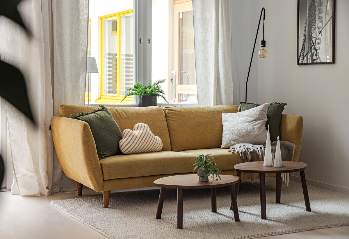 Visningslägenhet i Atlantis med fokus på gul soffa i vardagsrum