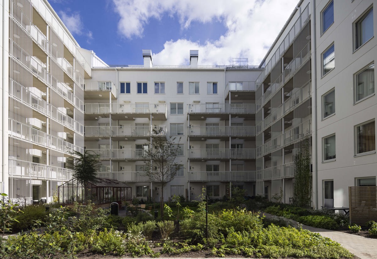 En grönskande innergård med flerfamiljshus runt om