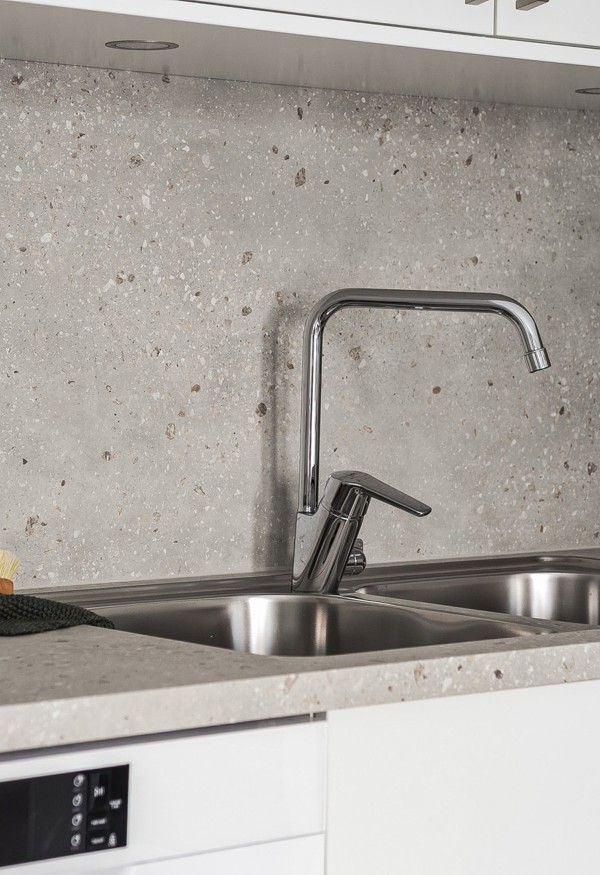 Visningslägenhet i Atlantis med fokus på detaljer som bänkskiva, luckor, handtag och stänkskydd