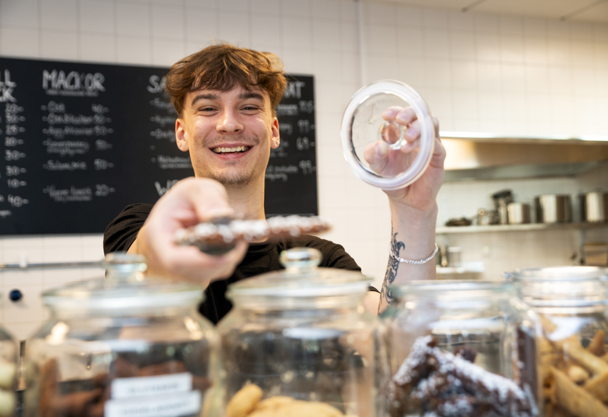 Bild på man i bageri som ger en kaka