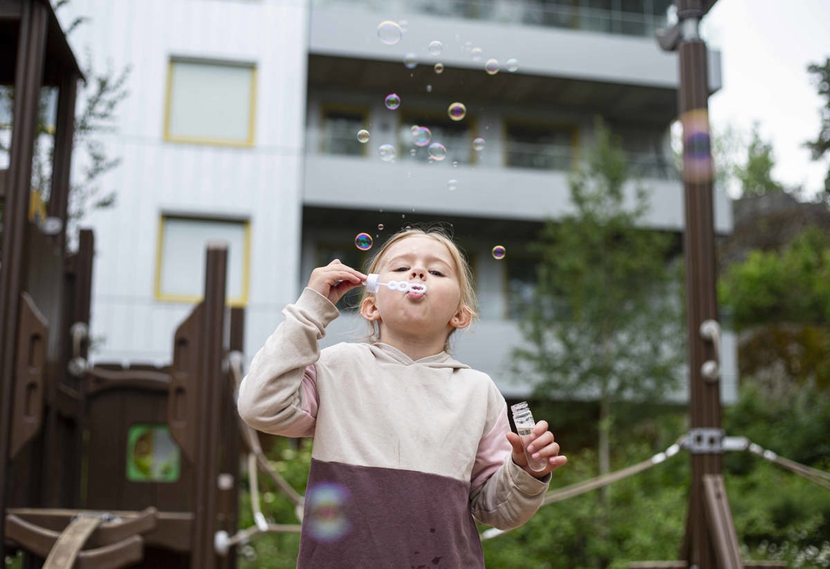 Flicka som blåser såpbubblor i en lekpark i Vega