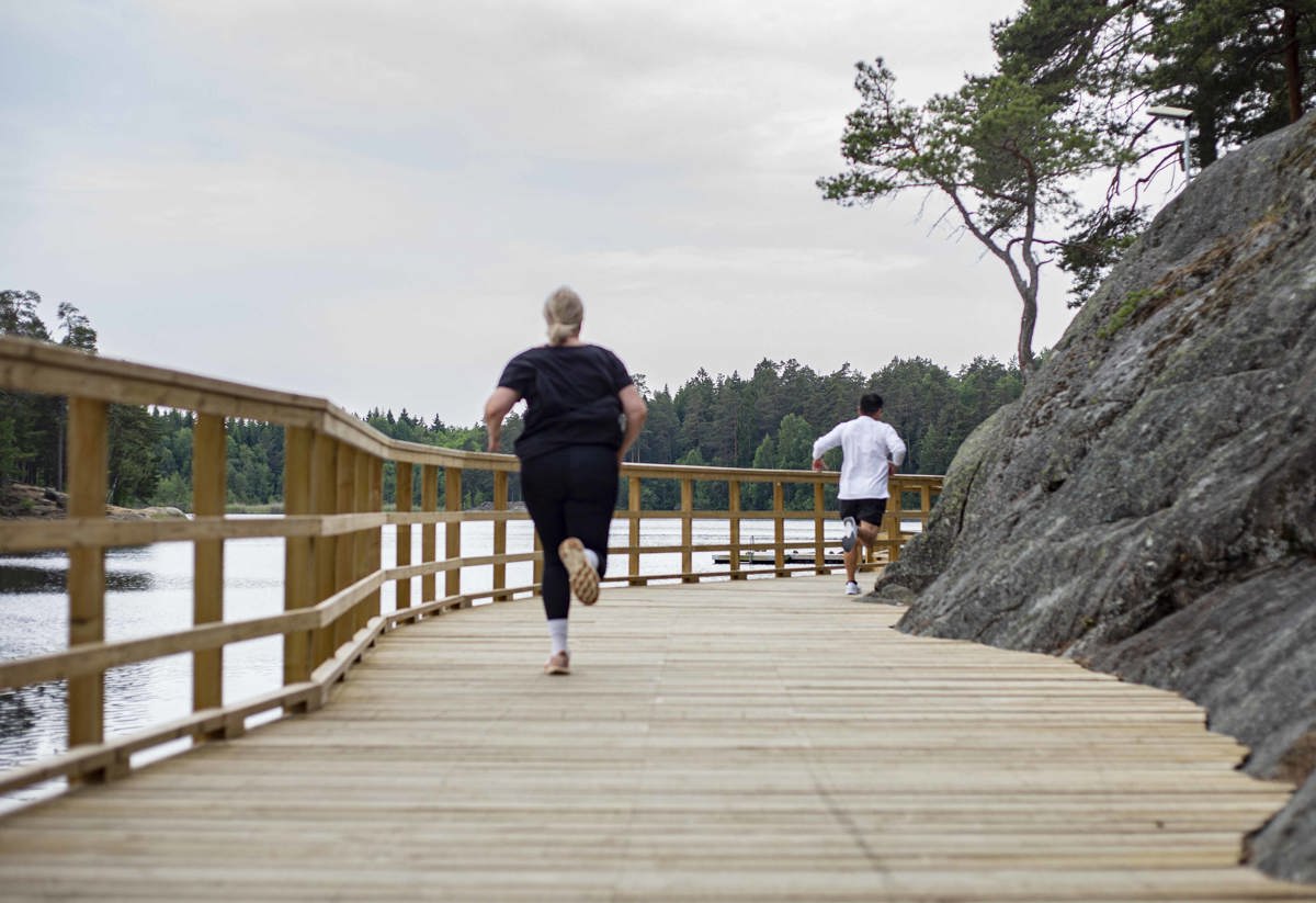 Två personer springer längs med en sjö i Rudan