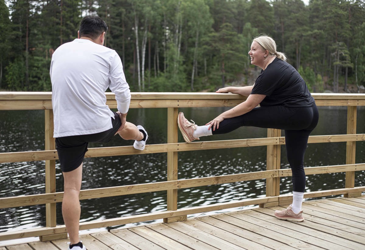 Två personer stretchar efter ett löppass runt i Rudan